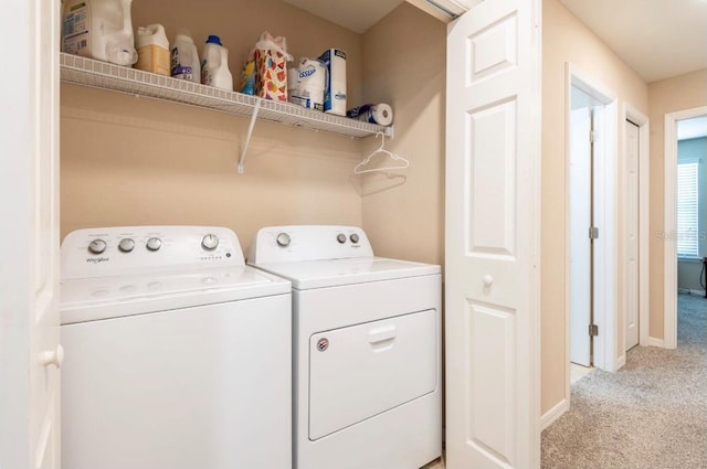 laundry area with separate washer and dryer and light colored carpet