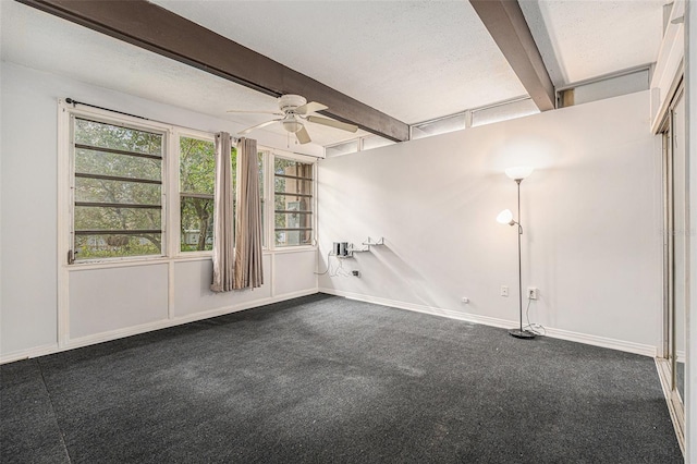 carpeted empty room featuring beamed ceiling, ceiling fan, and a textured ceiling