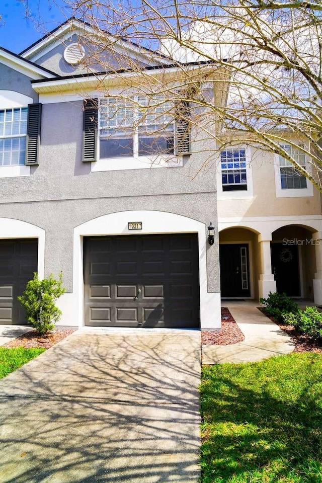 view of front of property featuring stucco siding, driveway, and an attached garage