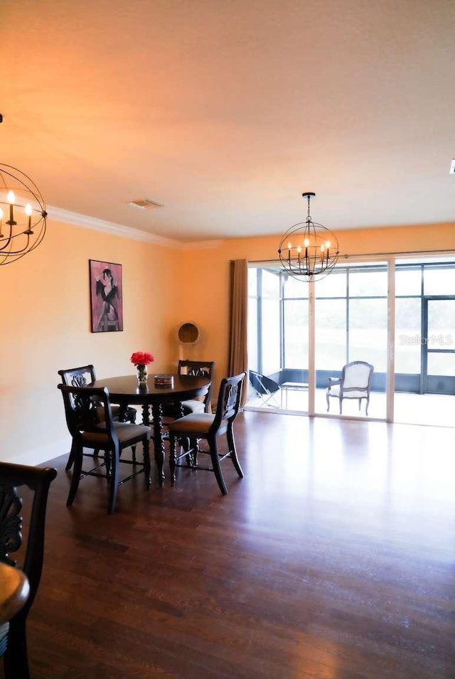 dining room featuring dark wood finished floors, a notable chandelier, and ornamental molding