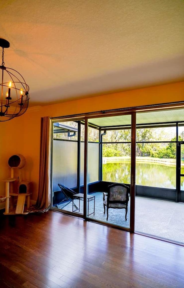 spare room featuring a notable chandelier, wood finished floors, and a textured ceiling