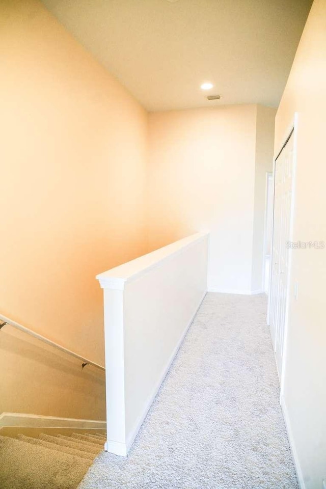 corridor featuring recessed lighting, an upstairs landing, and carpet floors