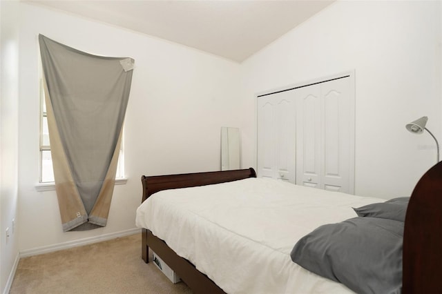 bedroom featuring light carpet, baseboards, and a closet