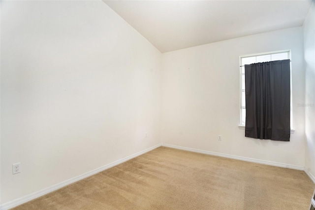 spare room with light carpet and baseboards