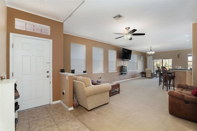 interior space featuring light tile patterned floors, light colored carpet, visible vents, baseboards, and ceiling fan with notable chandelier