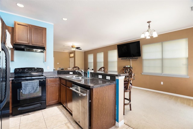 kitchen with stainless steel dishwasher, under cabinet range hood, brown cabinetry, and black electric range oven