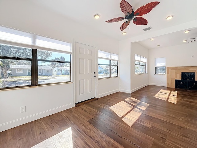 foyer with a fireplace, dark hardwood / wood-style floors, and ceiling fan