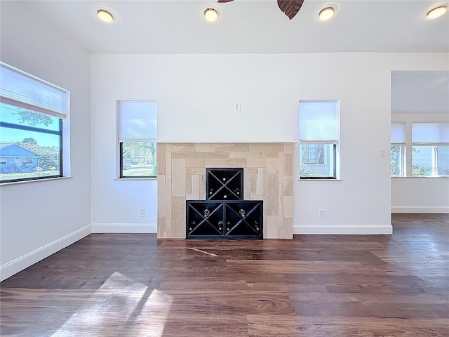 unfurnished living room featuring a healthy amount of sunlight and dark hardwood / wood-style floors