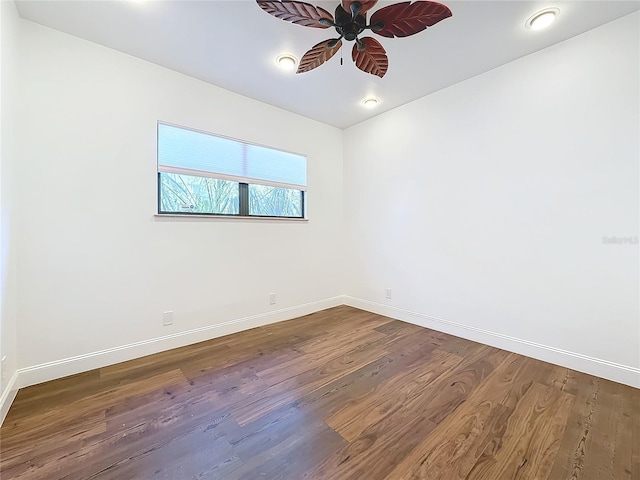 empty room with dark hardwood / wood-style flooring and ceiling fan