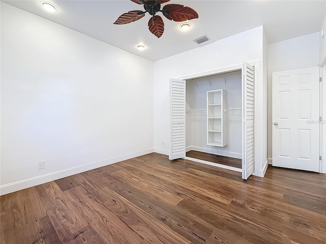 unfurnished bedroom with dark hardwood / wood-style flooring, a closet, and ceiling fan