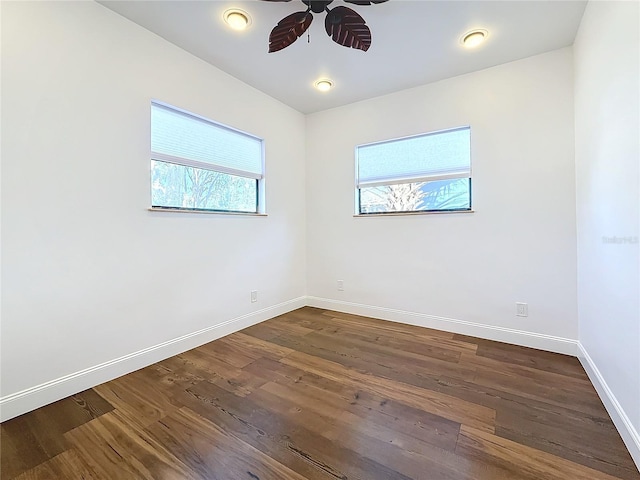 empty room with dark wood-type flooring and ceiling fan