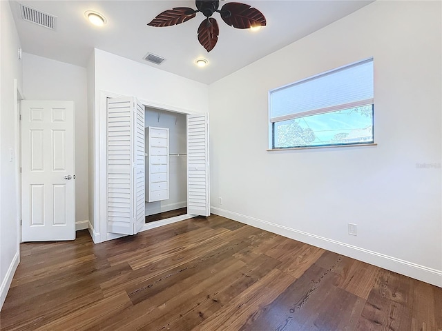 unfurnished bedroom with dark hardwood / wood-style floors, ceiling fan, and a closet