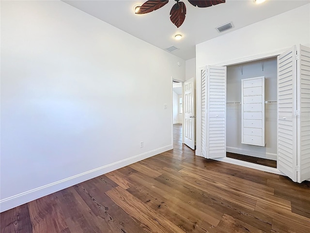 unfurnished bedroom with dark wood-type flooring, ceiling fan, and a closet