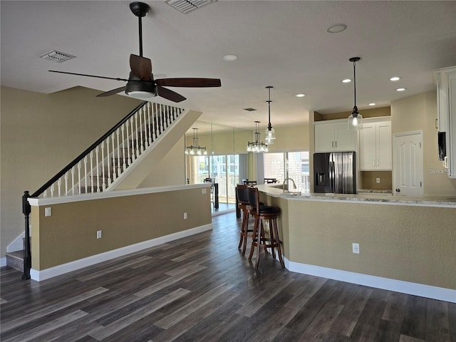 kitchen with decorative light fixtures, dark hardwood / wood-style floors, refrigerator with ice dispenser, ceiling fan, and white cabinets