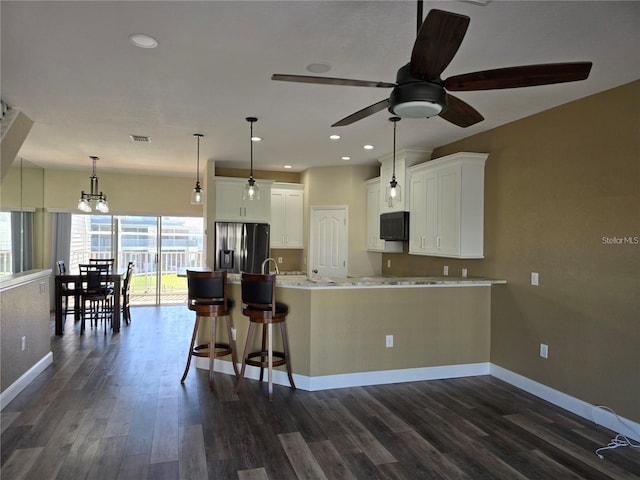 kitchen with pendant lighting, a breakfast bar, white cabinetry, dark hardwood / wood-style flooring, and stainless steel fridge with ice dispenser