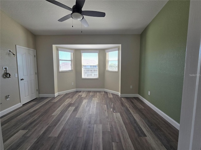 spare room featuring ceiling fan, dark hardwood / wood-style floors, and a textured ceiling