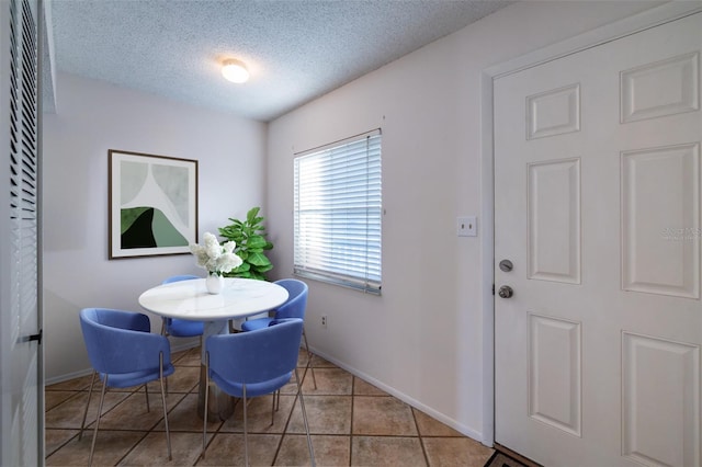 dining space with light tile patterned floors and a textured ceiling