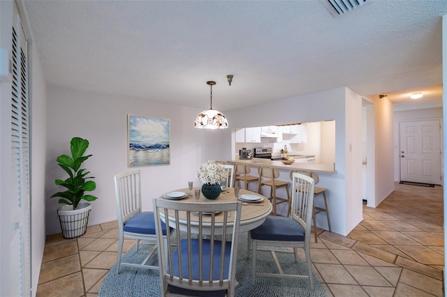 tiled dining room featuring a textured ceiling