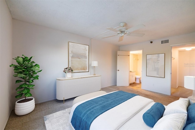 carpeted bedroom featuring ceiling fan, connected bathroom, and a textured ceiling