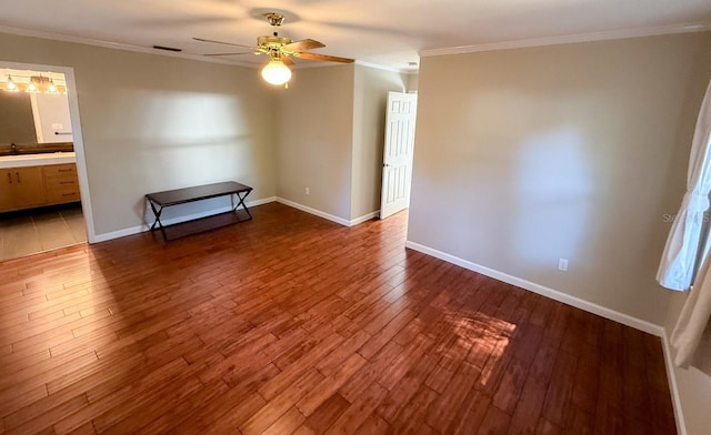 empty room featuring wood-type flooring, ceiling fan, and crown molding