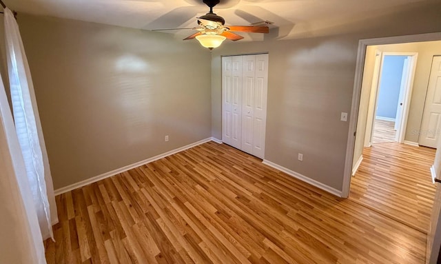 unfurnished bedroom featuring a closet, ceiling fan, and light hardwood / wood-style flooring