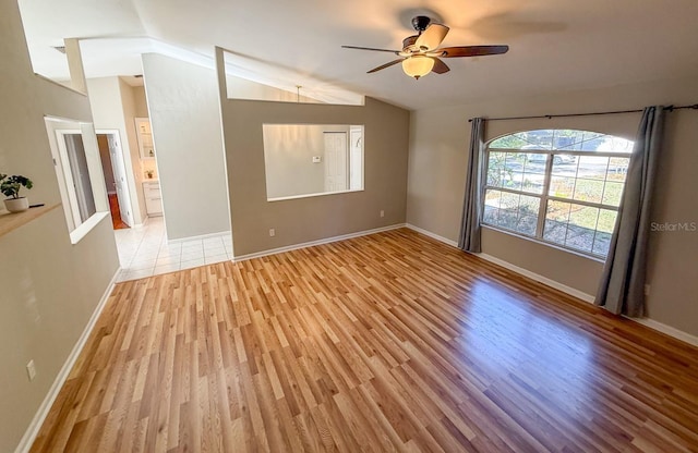 unfurnished room with vaulted ceiling, ceiling fan, and light wood-type flooring