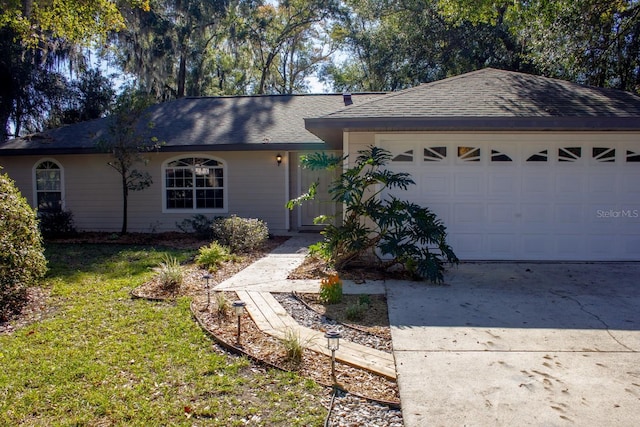 ranch-style house featuring a garage and a front lawn