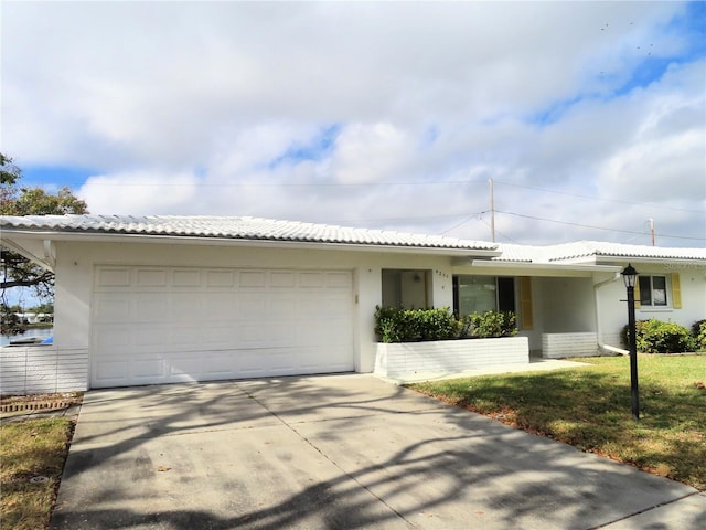 ranch-style home with a garage and a front lawn