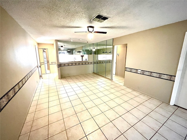 kitchen with light tile patterned floors, a textured ceiling, ceiling fan, and green cabinets