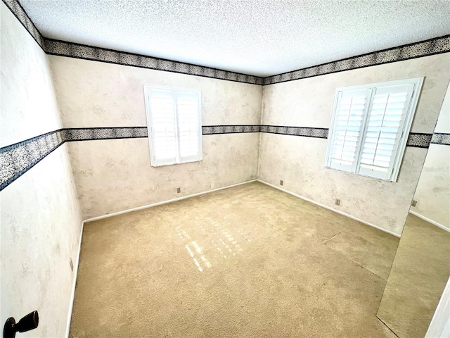 unfurnished room featuring carpet and a textured ceiling