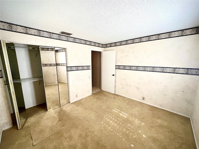 unfurnished bedroom featuring a closet, light colored carpet, and a textured ceiling