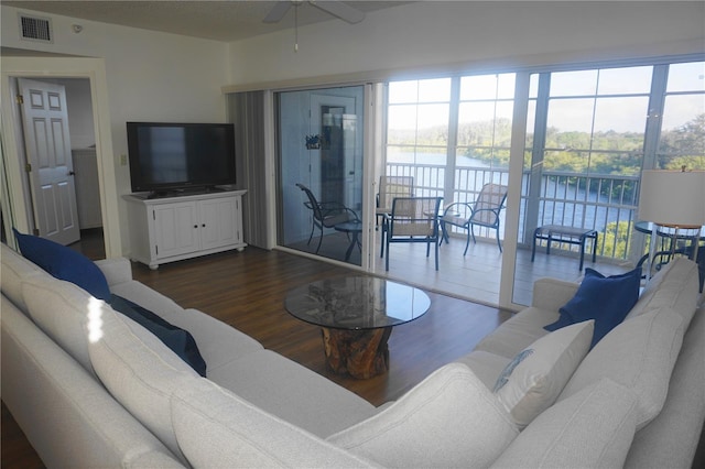 living room featuring a water view, ceiling fan, and dark hardwood / wood-style floors