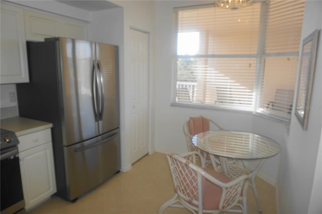 kitchen with appliances with stainless steel finishes, a wealth of natural light, and white cabinets