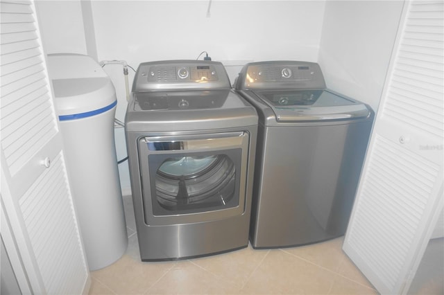 clothes washing area featuring light tile patterned flooring and washing machine and clothes dryer