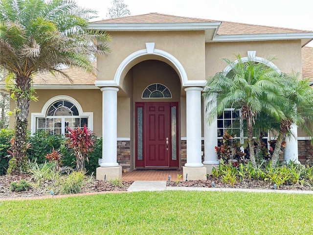 entrance to property featuring a lawn