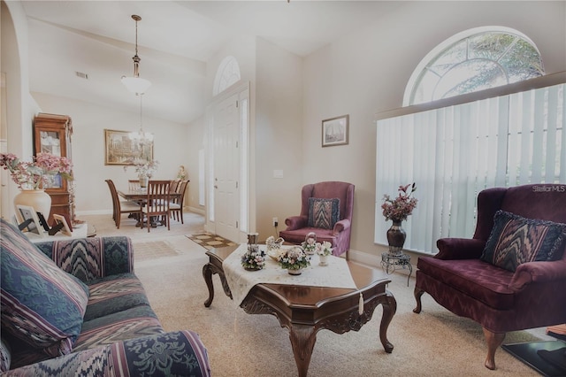 living room featuring light carpet, vaulted ceiling, and a chandelier