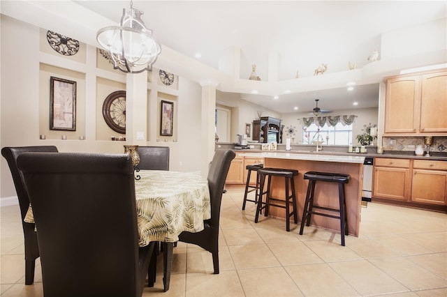 dining area with light tile patterned floors and ceiling fan with notable chandelier