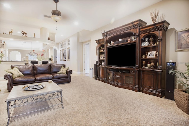 carpeted living room with ceiling fan