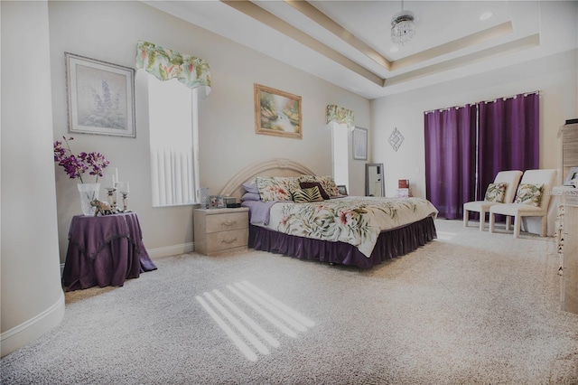 bedroom with carpet flooring and a tray ceiling