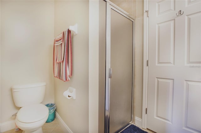 bathroom with toilet, an enclosed shower, and tile patterned flooring