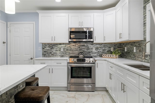 kitchen featuring sink, crown molding, appliances with stainless steel finishes, white cabinets, and backsplash