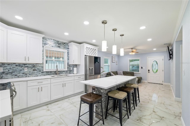 kitchen featuring white cabinetry, a kitchen breakfast bar, and sink