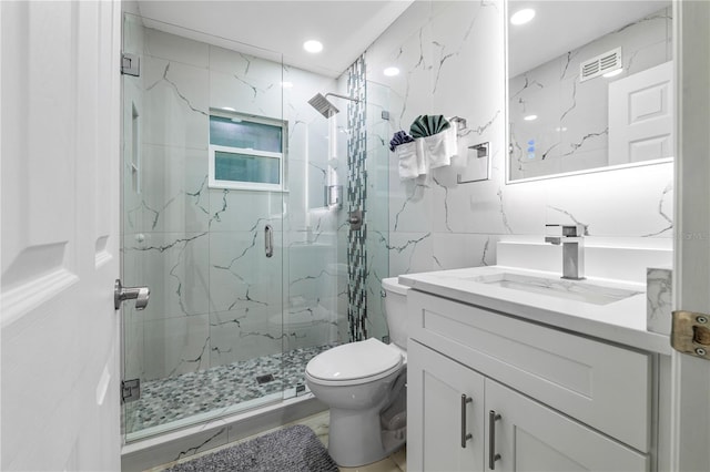 bathroom with vanity, tile walls, toilet, and walk in shower