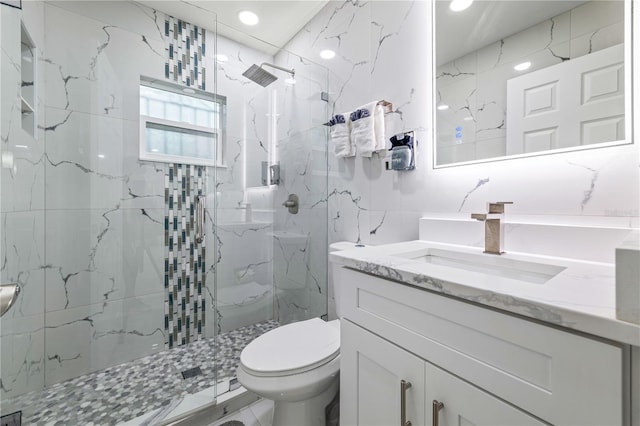 bathroom featuring vanity, toilet, tile walls, and a tile shower