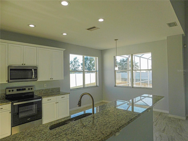 kitchen with white cabinetry, appliances with stainless steel finishes, decorative light fixtures, and sink