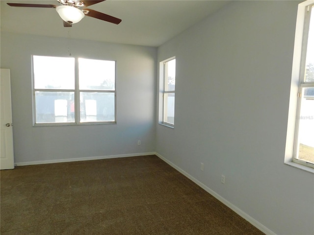 unfurnished room featuring ceiling fan and dark colored carpet