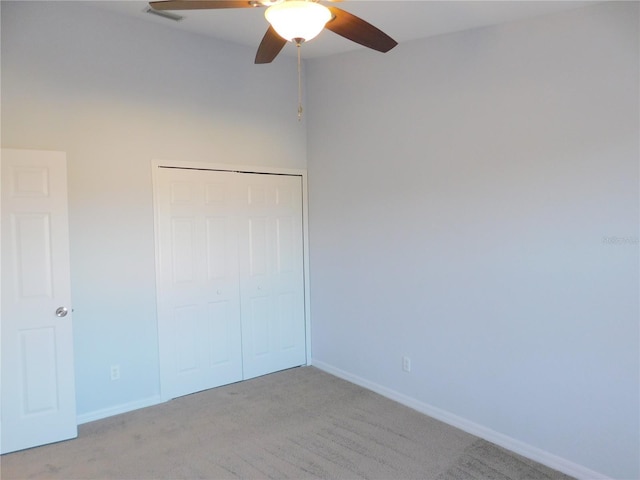 unfurnished bedroom featuring light colored carpet, a closet, and ceiling fan