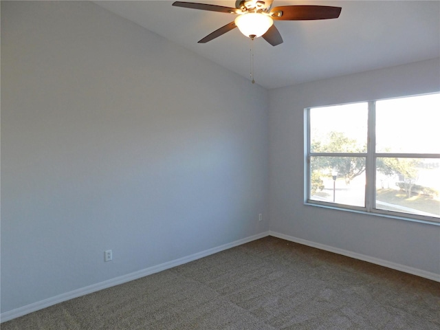 carpeted spare room featuring vaulted ceiling and ceiling fan