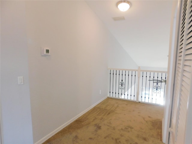 hallway with vaulted ceiling and carpet