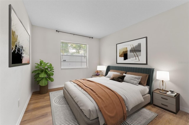 bedroom with a textured ceiling and light hardwood / wood-style flooring